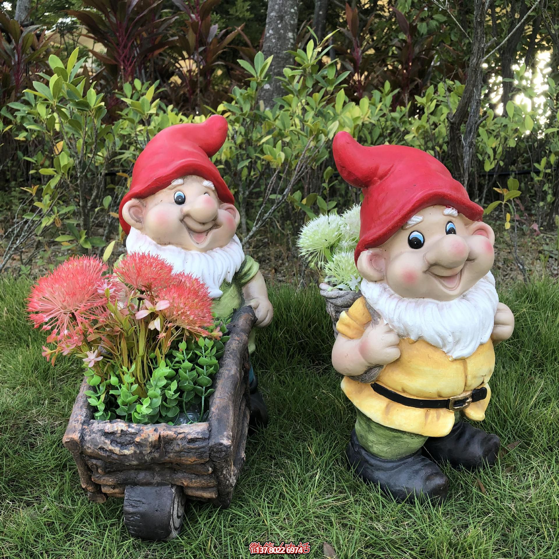 公園里擺放的一只手推花車和一個(gè)背筐的玻璃鋼卡通藍(lán)精靈雕塑